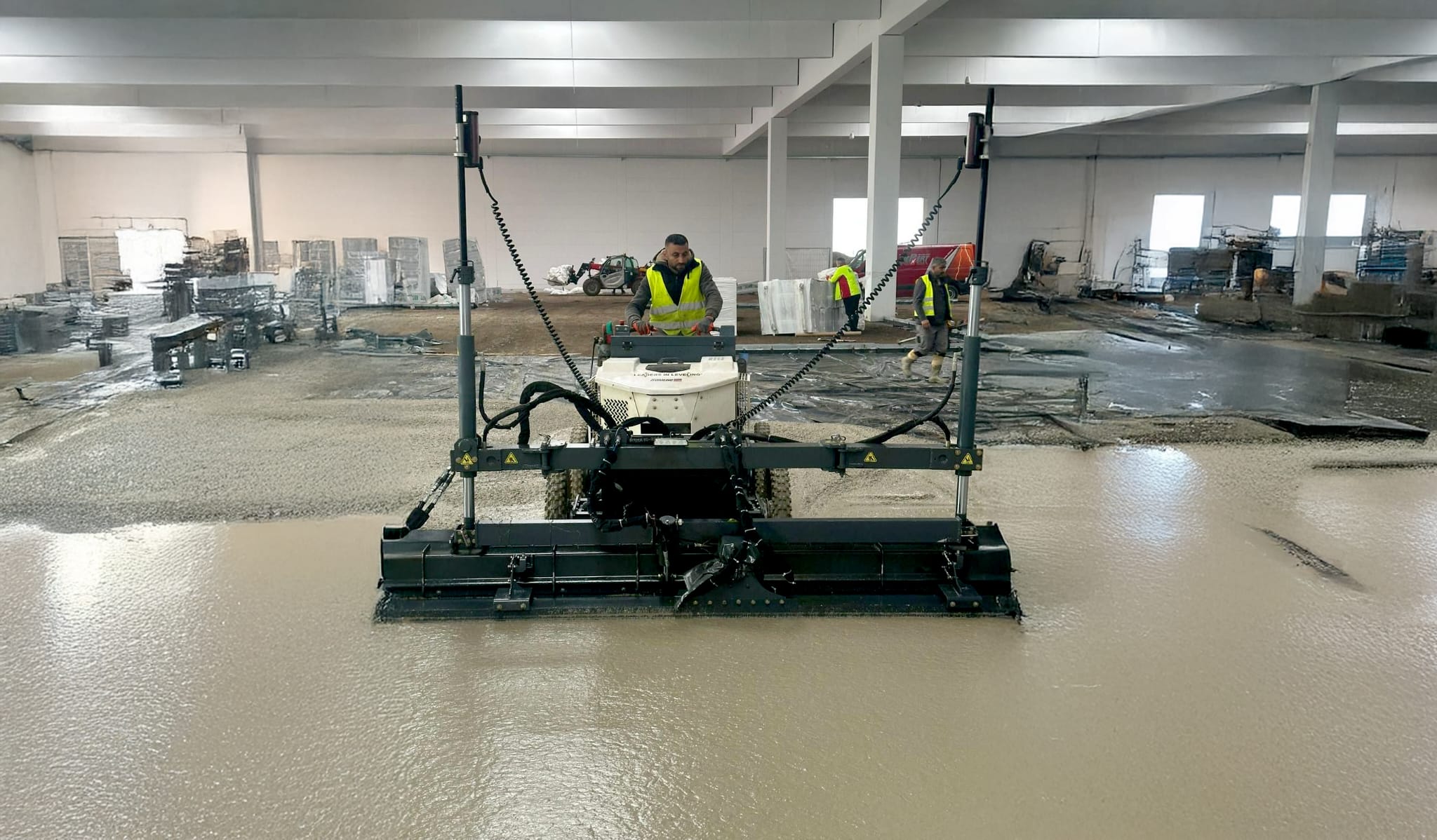 Laser-Screed-Maschine beim Betonieren einer Industriehalle